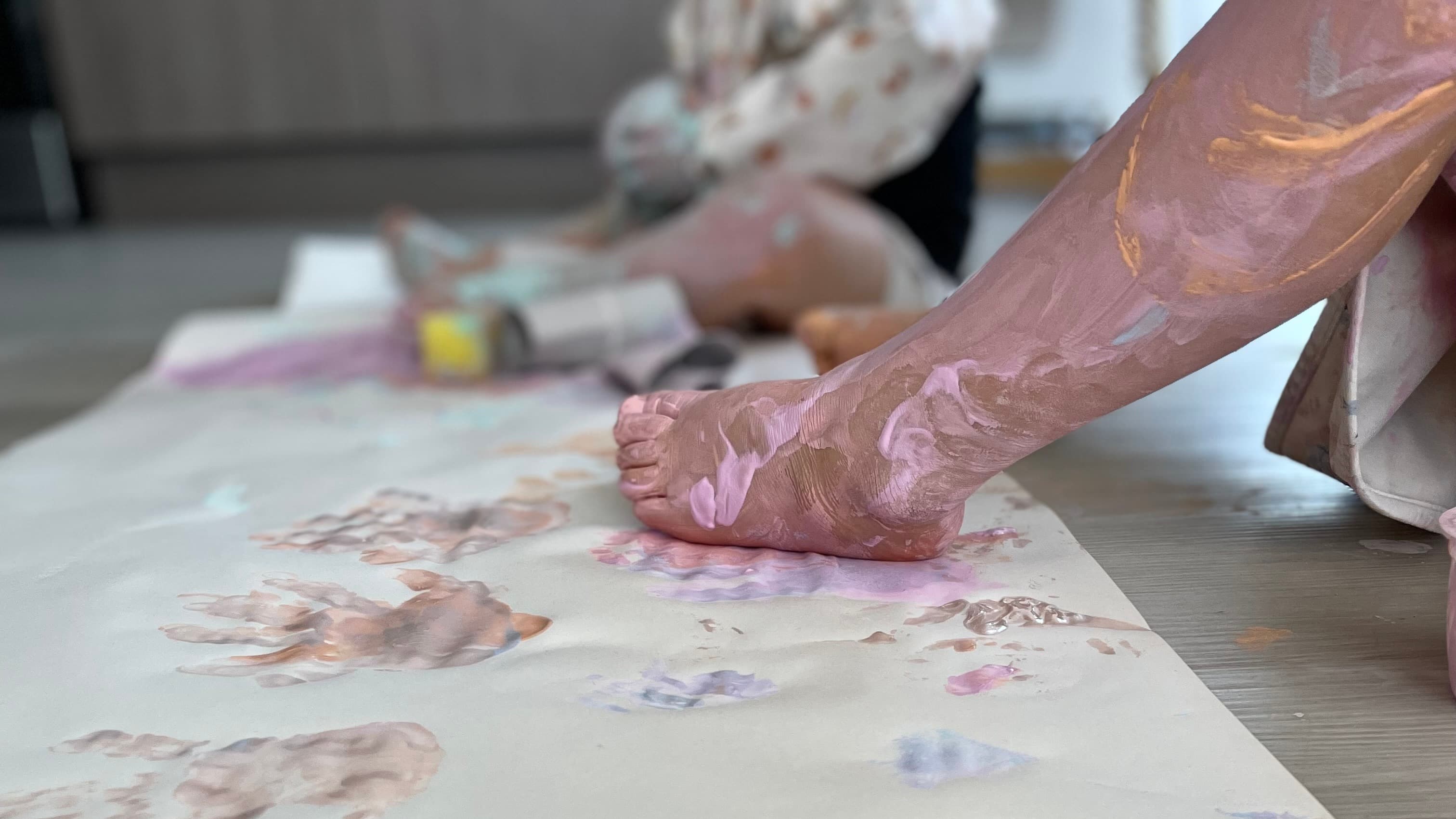 Un enfant peint au sol pendant une activité créative